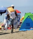 street vendor walks on the beach to sell rugs Royalty Free Stock Photo