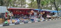 Street vendors sell children\'s toys on the pedestrian path using blue and orange tarpaulins.