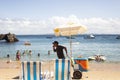 Street vendors walk on the sand of Porto da Barra beach