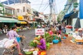 Street of Vietnamese fruit and vegetable vendors camped on sidewalk in front of shops