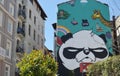 Street view of apartment buildings and a building with a graffiti work