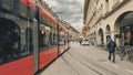 Street view of Bern. Red tram goes on the street near walking people