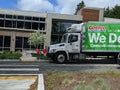 Street view of a Costco Business delivery truck parked on the side of the road downtown