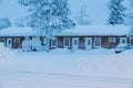 Street view of a Finnish town in winter, with snow-covered woods, road, cars and houses Royalty Free Stock Photo