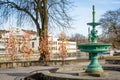 Street view of inactive fountain with traditional colourful feathers on trees for Easter decorations in Uppsala, Sweden, Europe