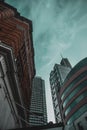 Street view looking up into the massive skyscrapers of london city, several tall buildings illuminated by teal sunlight.Old orange Royalty Free Stock Photo