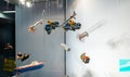 Street view of multiple toys hanged in the showcase of toy store - motorcyclists, boats, rockets, trains