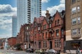 Street view of an old, red brick apartment building with modern office skyscraper behind Royalty Free Stock Photo