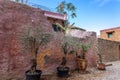 Street view of old town of Rhodes, Greece. Pots with flowers standing on paved pavement along stone wall. Royalty Free Stock Photo