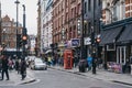 Street view of people walking past theatres and restaurants in Covent Garden, London, UK