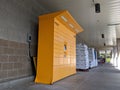 Street view of a set of bright yellow Amazon parcel lockers outside of a grocery store