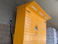 Street view of a set of bright yellow Amazon parcel lockers outside of a grocery store