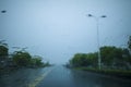 Street view taken through the windshield of the car in rainy weather