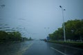 Street view taken through the windshield of the car in rainy weather