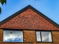 Street View of top of modern brick built house with tiled gable end. Royalty Free Stock Photo