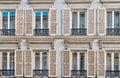 Street view of traditional French windows with shutters and wrought iron railings in Paris, France. Royalty Free Stock Photo