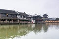 Street view with wooden historic buildings and buddhist temple in Zhujiajiao in a rainy day, an ancient water town in Shanghai,