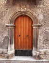Old wooden door in the medieval city in Italy. Ancient wall of old building with wooden vintage door. Royalty Free Stock Photo