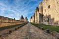 Street among the walls of an old medieval castle under blue ski