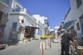 A street with white houses with blue trim and a market with plates