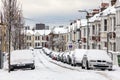 Street winter cityscape with snow terraced houses and frozen cars