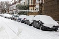 Street winter cityscape with snow terraced houses and frozen cars