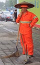 Street worker is cleaning side walk with broom tool
