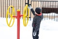 Street workout equipment in winter, outdoor sport fitness and bodybuilding. Boy in a sport playground Royalty Free Stock Photo