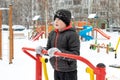 Street workout equipment in winter, outdoor sport fitness and bodybuilding. Boy in a sport playground doing workout exercises Royalty Free Stock Photo