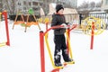 Street workout equipment in winter, outdoor sport fitness and bodybuilding. Boy in a sport playground doing workout exercises Royalty Free Stock Photo