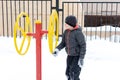 Street workout equipment in winter, outdoor sport fitness and bodybuilding. Boy in a sport playground Royalty Free Stock Photo