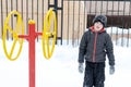 Street workout equipment in winter, outdoor sport fitness and bodybuilding. Boy in a sport playground Royalty Free Stock Photo