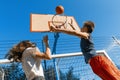 Streetball basketball game with two players, teenagers girl and boy with ball, outdoor city basketball court Royalty Free Stock Photo