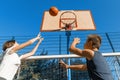 Streetball basketball game with two players, teenagers girl and boy with ball, outdoor city basketball court Royalty Free Stock Photo