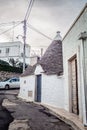 A streetcorner with a typical white cottage in alberobello with nice pointed roofs