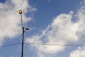 Streetlights glowing under fluffy white clouds Royalty Free Stock Photo