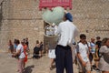 On the streets of Dubrovnik Croatia, happy vacationers walk and buy souvenirs from the seller in the national festive