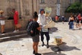 On the streets of Dubrovnik Croatia, happy vacationers walk and buy souvenirs from the seller in the national festive