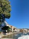 Streets leading to the sea in Old FoÃÂ§a, houses in front of the sea, people swimming in the sea, boats.