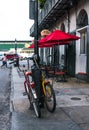 Streets of the old New Orleans city. A pair of old-fashioned bicycles near a street cafe with red umbrellas