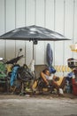 The streets of Saigon Ho Chi Min City, a man fixing a motorbike is sleeping on the sidewalk