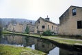 Streets of terraced houses alongside the rochdale canal in hebden bridge with buildings reflected in the water in winter Royalty Free Stock Photo