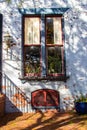 Streetscape including lime washed brick, window and antique lantern.