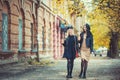 Streetstyle and fashion! Outdoors shot of young women with coffee on city street. Two fashion girls walking outdoor with cofee. Royalty Free Stock Photo
