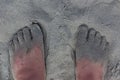 Feet covered in wet and dry sand on a beach in California Royalty Free Stock Photo