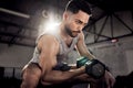 Strength does not come from physical capacity. a muscular young man exercising with a dumbbell in a gym. Royalty Free Stock Photo