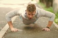 Strength and motivation. Man in sportswear doing push ups outdoor. Guy motivated workout in park. Sportsman improves his Royalty Free Stock Photo