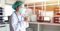 Stress Asian doctor in uniform suit, medical mask and cap make a praying in hospital during transmission of Covid-19 coronavirus