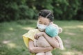 Stress asian little girl holding toy bear wearing medical protective mask Royalty Free Stock Photo