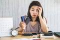 Stress Asian woman looking at credit cards in hand no money for debt